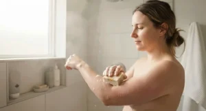 Person using a gentle plant-based soap for eczema in a shower, highlighting hypoallergenic skincare for Canadians.