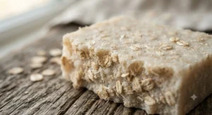 Close-up of the rough texture of exfoliating goat milk oatmeal soap showing embedded oat flakes.